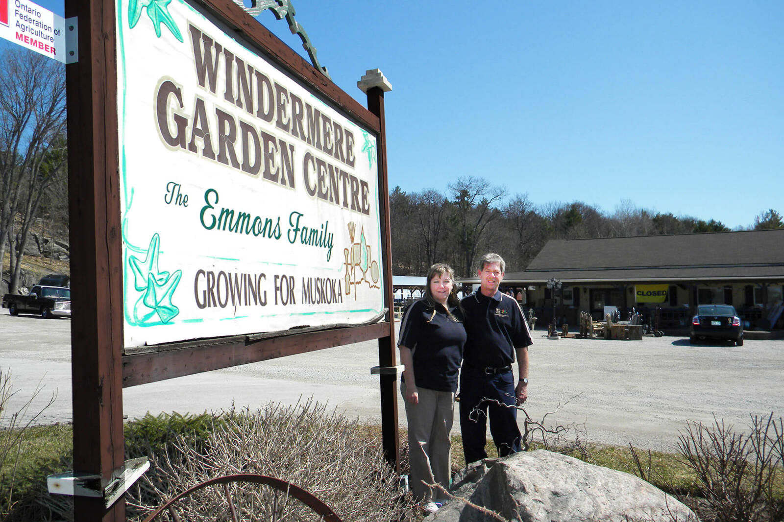 couple standing outside a sign for their business